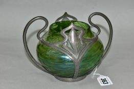 AN EARLY 20TH CENTURY LOETZ STYLE IRIDESCENT GREEN GLASS BOWL IN A SCROLLING PEWTER TWIN HANDLED