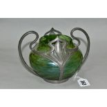 AN EARLY 20TH CENTURY LOETZ STYLE IRIDESCENT GREEN GLASS BOWL IN A SCROLLING PEWTER TWIN HANDLED