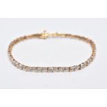 A 9CT DIAMOND LINE BRACELET, designed with a row of individual claw set, single cut diamonds,