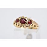 AN 18CT GOLD GARNET AND DIAMOND GYPSY RING, designed with a central oval cut garnet, flanked with