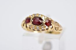 AN 18CT GOLD GARNET AND DIAMOND GYPSY RING, designed with a central oval cut garnet, flanked with