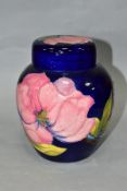 A MOORCROFT POTTERY GINGER JAR AND COVER DECORATED WITH PINK MAGNOLIA, dark blue ground, impressed