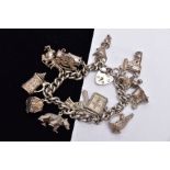 A HEAVY SILVER CHARM BRACELET, suspending fourteen charms in various forms such as a tankard,