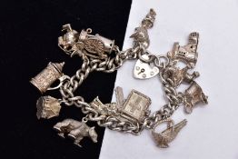 A HEAVY SILVER CHARM BRACELET, suspending fourteen charms in various forms such as a tankard,