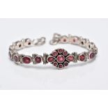 A WHITE METAL, GARNET SET LINE BRACELET, articulated bracelet, designed with a central cluster of