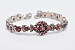 A WHITE METAL, GARNET SET LINE BRACELET, articulated bracelet, designed with a central cluster of