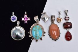 A BAG OF ASSORTED WITE METAL PENDANTS, eight pendants in total of various designs such as a