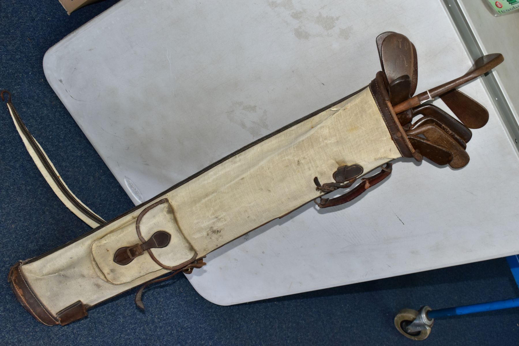 A VINTAGE CANVAS AND LEATHER TRIMMED GOLF BAG CONTAINING ELEVEN WOODEN SHAFTED GOLF CLUBS, brands