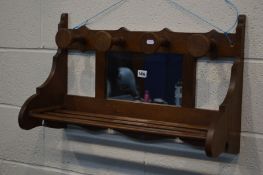 AN EARLY 20TH CENTURY OAK WALL SHELF, with four hooks and central mirror, width 72cm