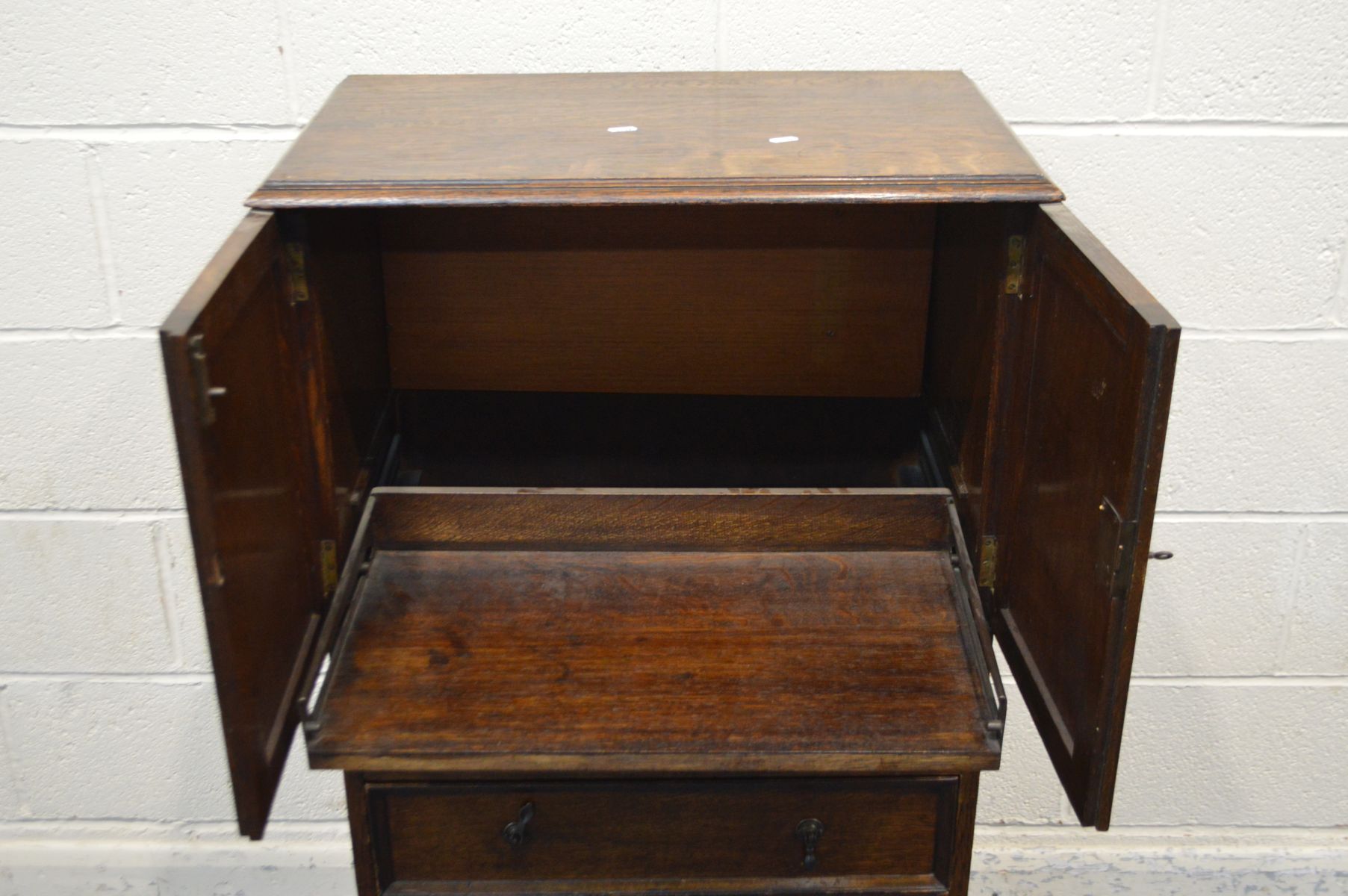 AN EARLY TO MID 20TH CENTURY SOLID OAK TWO DOOR CABINET, enclosing a sliding shelf, above three - Image 2 of 2