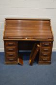 AN EARLY 20TH CENTURY OAK ROLL TOP DESK, with a fitted interior with an assortment of shelves and