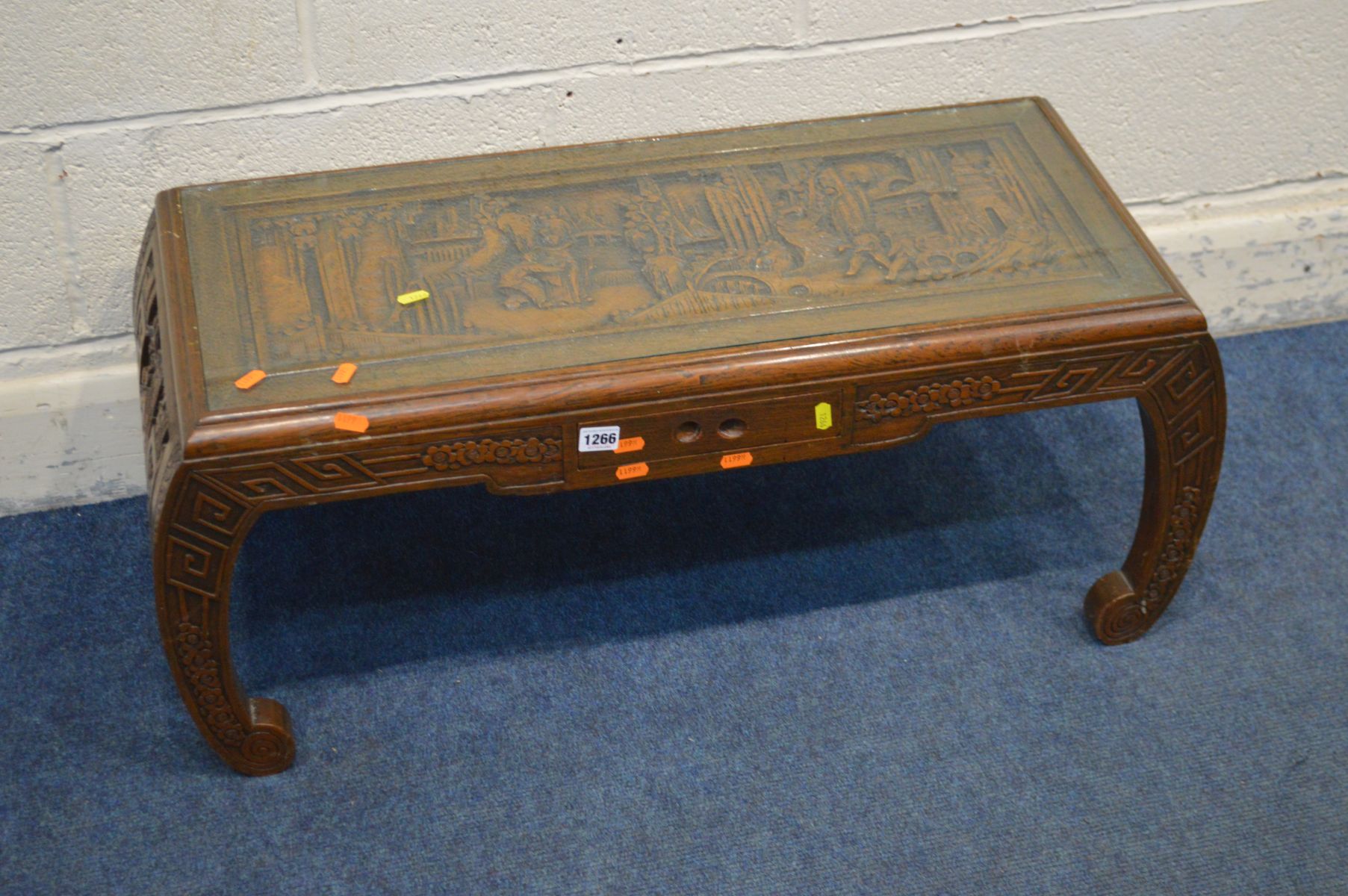 AN ORIENTAL HEAVILY CARVED CAMPHOR WOOD COFFEE TABLE, with glass insert, small frieze drawer on