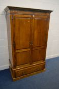 A REPRODUCTION OAK WARDROBE, with double solid oak panelled doors, labelled Rushworth's cabinet