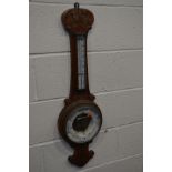 AN EARLY 20TH CENTURY CARVED OAK WHEEL BAROMETER, with a Mercury thermometer and ceramic dial (