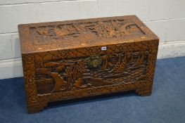 AN ORIENTAL HEAVILY CARVED CAMPHOR WOOD CHEST, decorated with marine scenes, width 94cm x depth 45cm