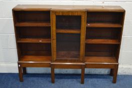 A LOW NARROW MAHOGANY SIDE BY SIDE OPEN BOOKCASE, with a central glazed cupboard door, on square