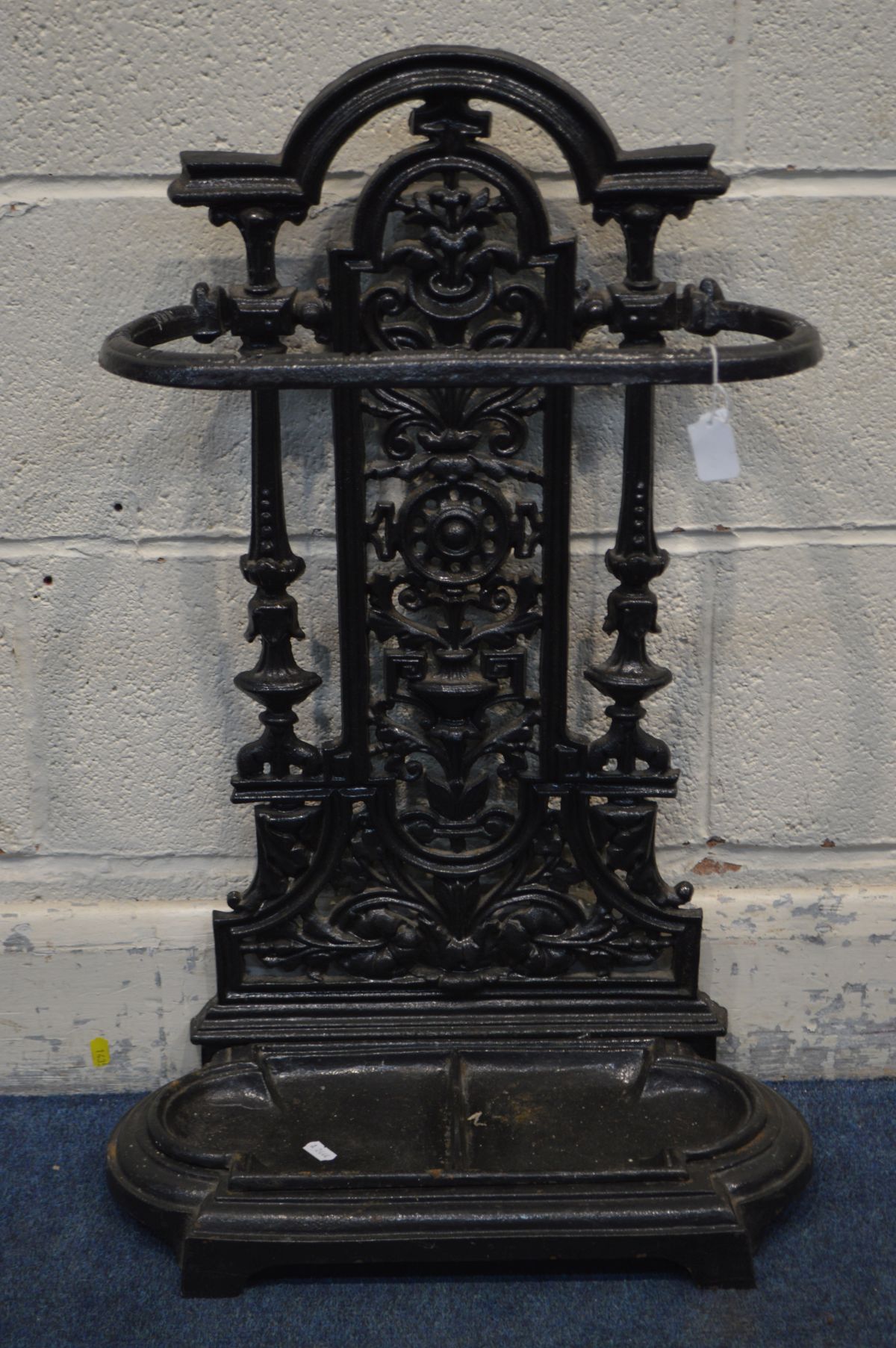 A CAST IRON UMBRELLA STAND, painted black, with a removable tray, height 70cm