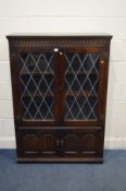 AN OAK LEAD GLAZED BOOKCASE with two adjustable shelves and two cupboard doors, width 97cm x depth