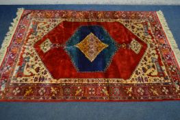 A SILK AFSHAR RUG, red field with central medallion within a blue border, 210cm x 141cm