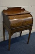 AN EDWARDIAN MAHOGANY AND STRING INLAID BARREL FRONT BUREAU, with a pull out slide, fitted interior,