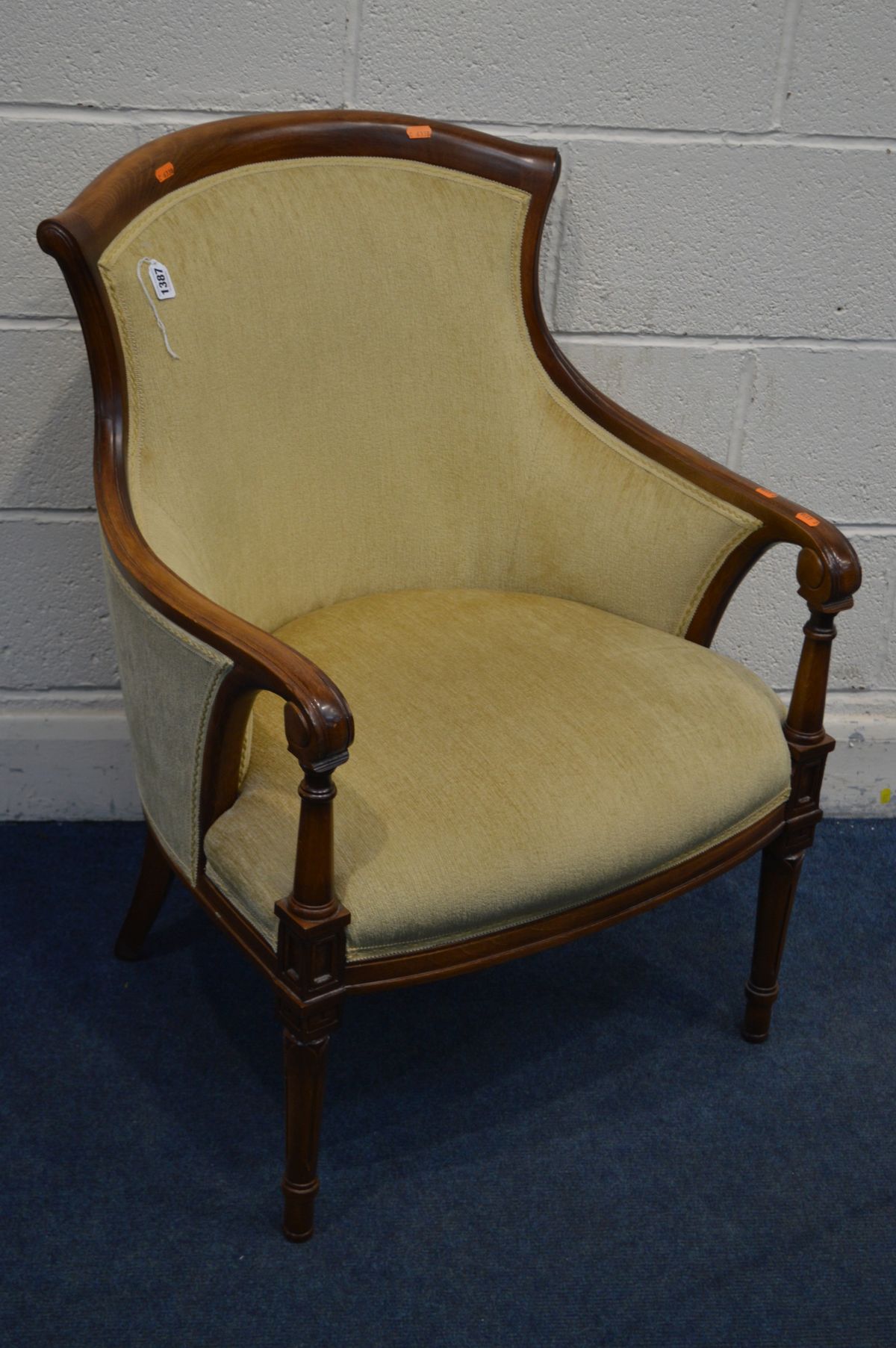 A REPRODUCTION MAHOGANY AND GOLD UPHOLSTERED FRENCH STYLE ARMCHAIR, on fluted front legs