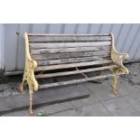 A DISTRESSED GARDEN BENCH with cast iron ends and slatted seat and back (some slats missing) 126cm
