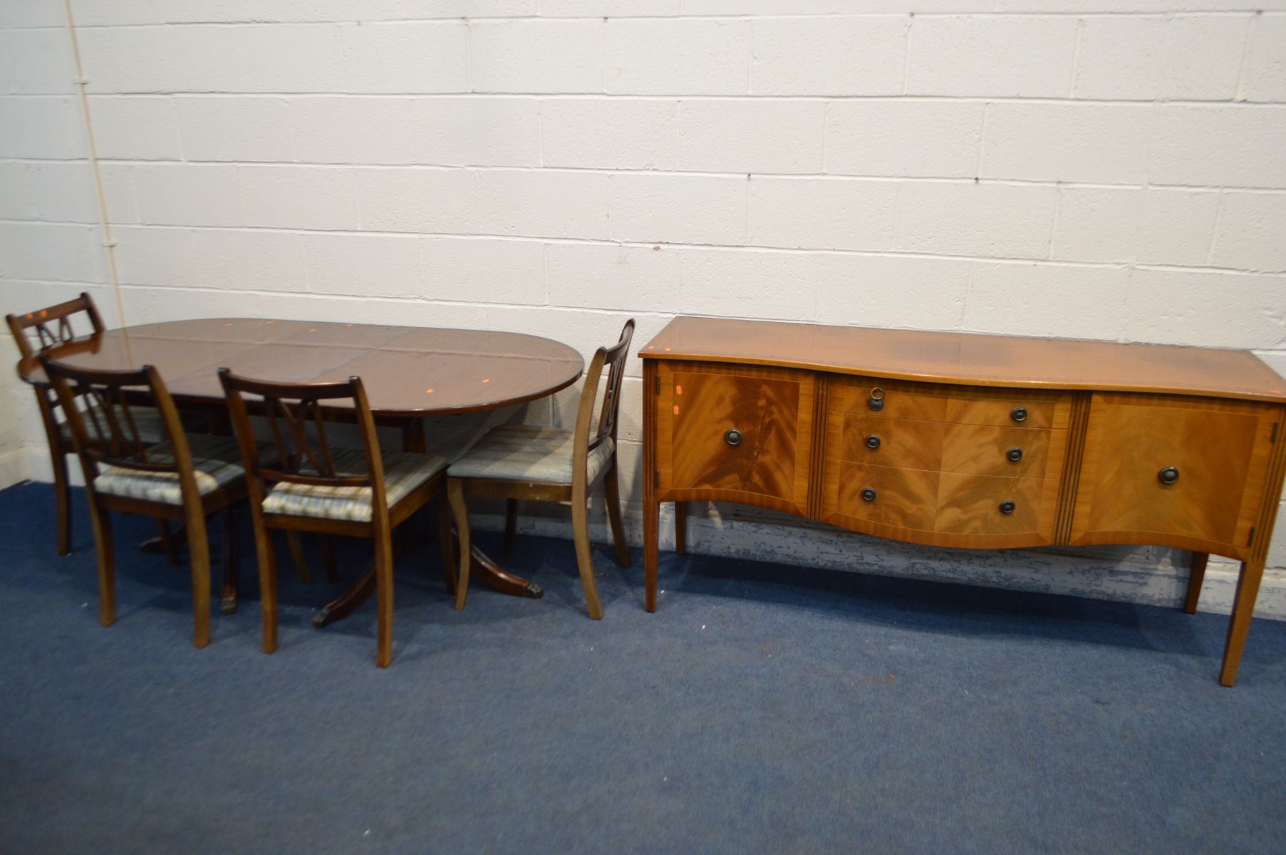 A MAHOGANY DINING TABLE, one additional leaf, four chairs and a serpentine sideboard (6)