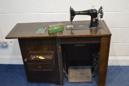 A MAHOGANY CASED SINGER TREDLE SEWING MACHINE, with a fold over and single door