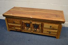 A MANGO WOOD AND IRON COFFEE TABLE, with four drawers, width 135cm x depth 61cm x height 47cm (Sd to