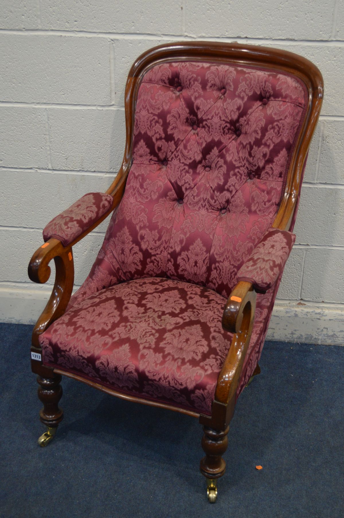 A VICTORIAN WALNUT OPEN ARMCHAIR with scrolled armrests, on turned front legs and brass casters,