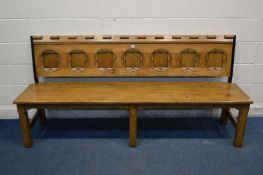 A REPRODUCTION OAK BENCH with seven carved panels to the back, length 202cm