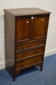 AN EARLY TO MID 20TH CENTURY SOLID OAK TWO DOOR CABINET, enclosing a sliding shelf, above three