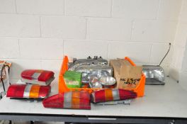 A TRAY CONTAINING VINTAGE CAR HEAD AND TAIL LIGHTS including a brand new old stock SAP Ford Sierra