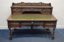 A LATE 19TH/EARLY 20TH CENTURY CARVED OAK DESK, with elaborate foliate decoration, the raised back