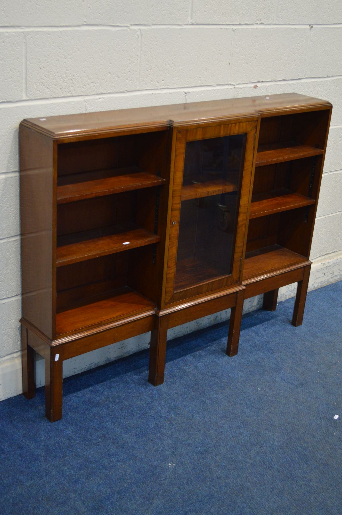 A LOW NARROW MAHOGANY SIDE BY SIDE OPEN BOOKCASE, with a central glazed cupboard door, on square - Image 2 of 2