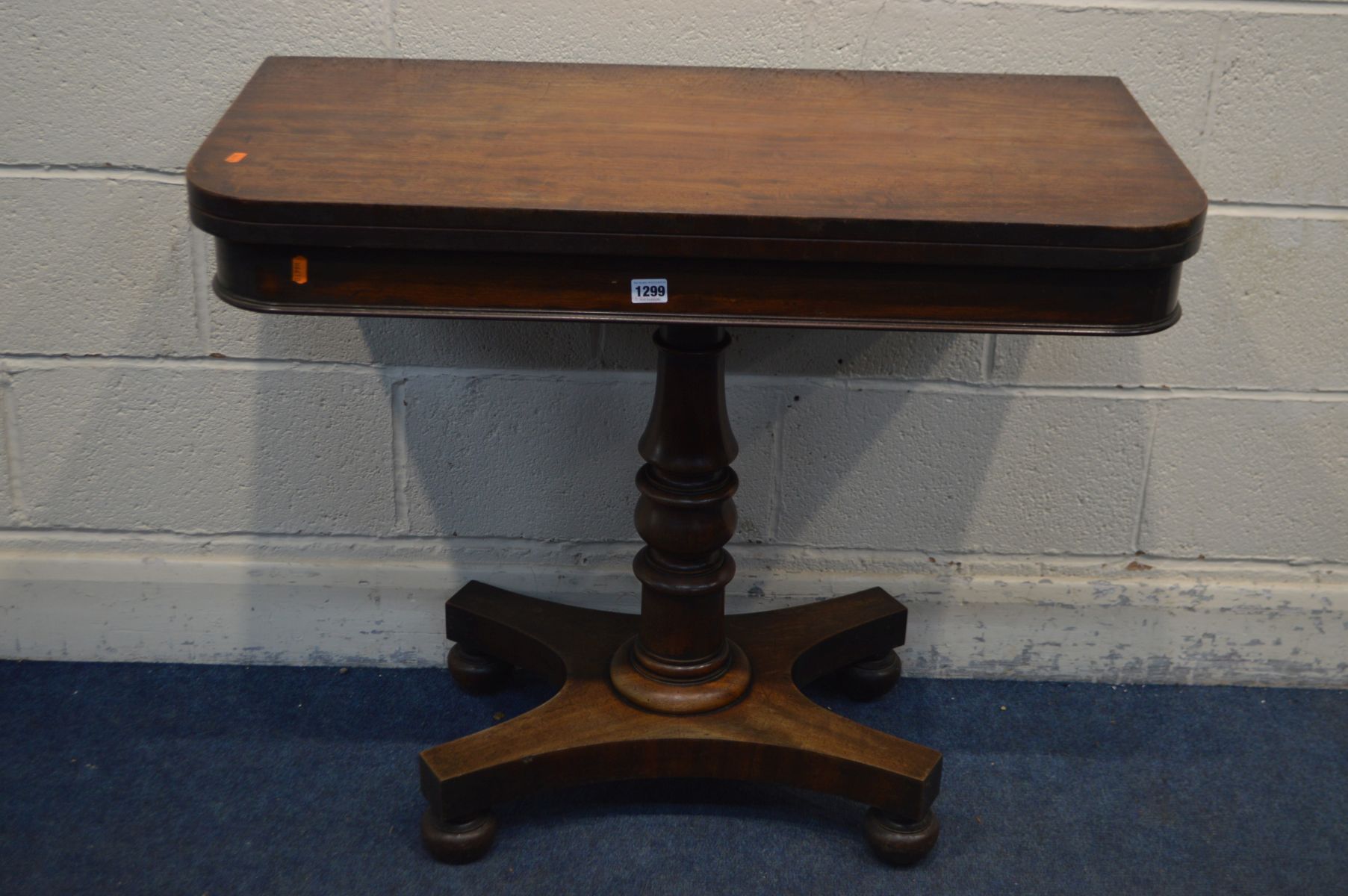 A VICTORIAN MAHOGANY CARD TABLE, the fold over top enclosing a green baize lining, on a single