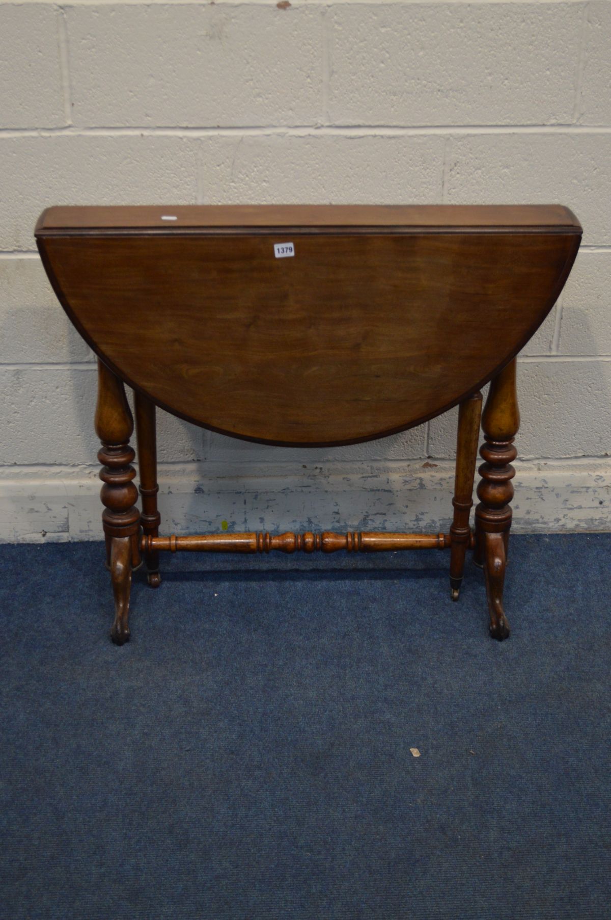 A VICTORIAN WALNUT OVAL CIRCULAR TOPPED SUTHERLAND TABLE, on turned supports to twin scrolled legs