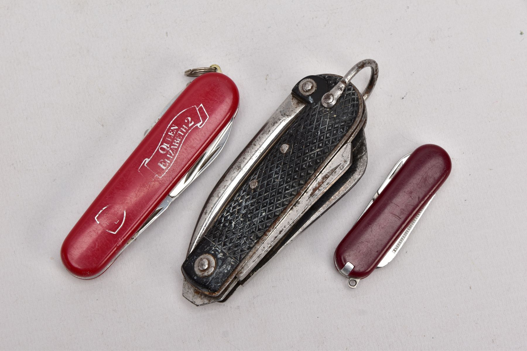 THREE POCKET KNIVES, to include a multi-purpose 'Queen Elizabeth II' pocket knife, a small red