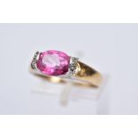 A 9CT GOLD PINK TOPAZ RING, designed with a tension set, oval cut pink topaz, single cut diamond