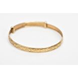 A 9CT GOLD CHRISTENING BANGLE, embossed heart and scroll design, hallmarked 9ct gold Birmingham,