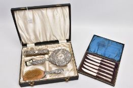 A CASED THREE PIECE SILVER VANITY SET AND A CASED SILVER HANDLED KNIFE SET, the black vanity case