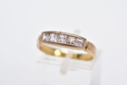 A YELLOW METAL HALF HOOP RING, designed with a row of graduated square cut colourless stones,