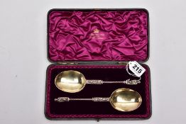 A CASED TWO PIECE LATE VICTORIAN SILVER GILT SPOON SET, brown case opens to reveal a purple velvet