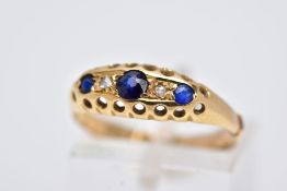AN EARLY 20TH CENTURY BOAT RING, set with three circular cut blue sapphires, interspaced with rose