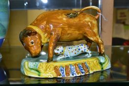 AN EARLY 19TH CENTURY STAFFORDSHIRE POTTERY BULL BAITING GROUP, on an oval moulded base, glazed in