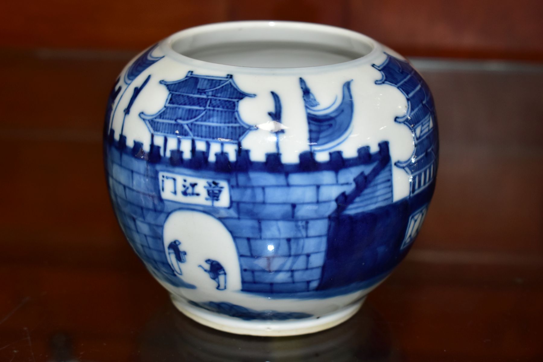 A CHINESE BLUE AND WHITE STORAGE JAR, decorated with figures in an arched doorway to a palace or