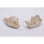 TWO MODERN ORIENTAL, WHITE METAL FILIGREE BOAT ORNAMENTS, one with a standing figure with paddle,