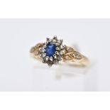 A 9CT GOLD SAPPHIRE AND DIAMOND CLUSTER RING, designed with a central claw set oval cut blue