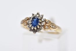 A 9CT GOLD SAPPHIRE AND DIAMOND CLUSTER RING, designed with a central claw set oval cut blue