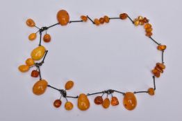 AN AMBER NECKLACE, designed with a mixture of transparent and butterscotch coloured amber in various